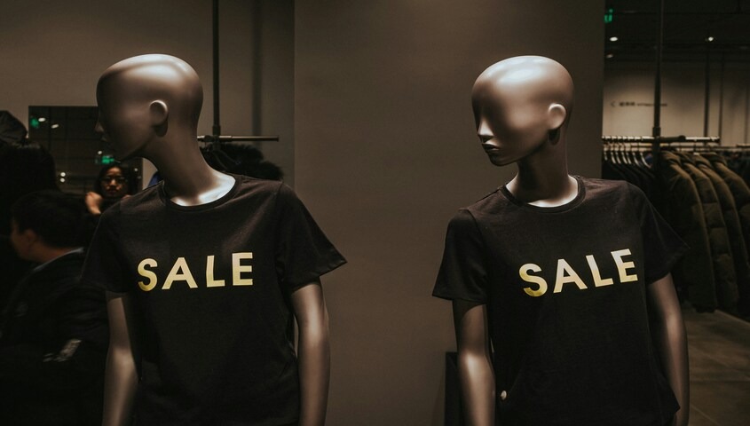 Retail mannequins in matching SALE t-shirts, showing the discount noise a black friday campaign has to cut through.