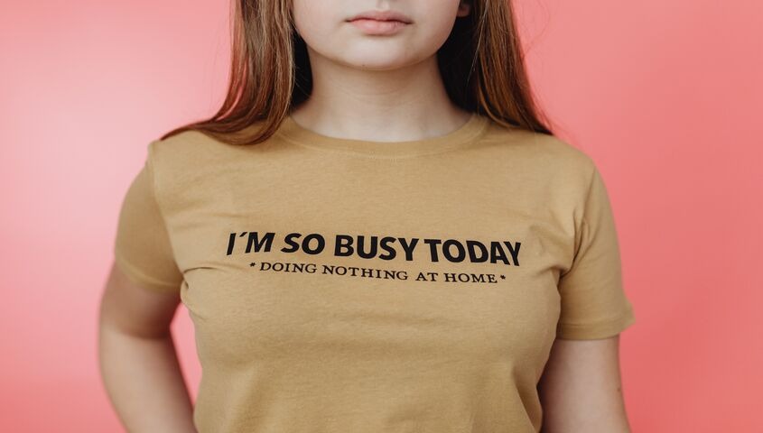 Woman wearing a text-only slogan tee against a pink backdrop, the typography approach leading trending print on demand designs.