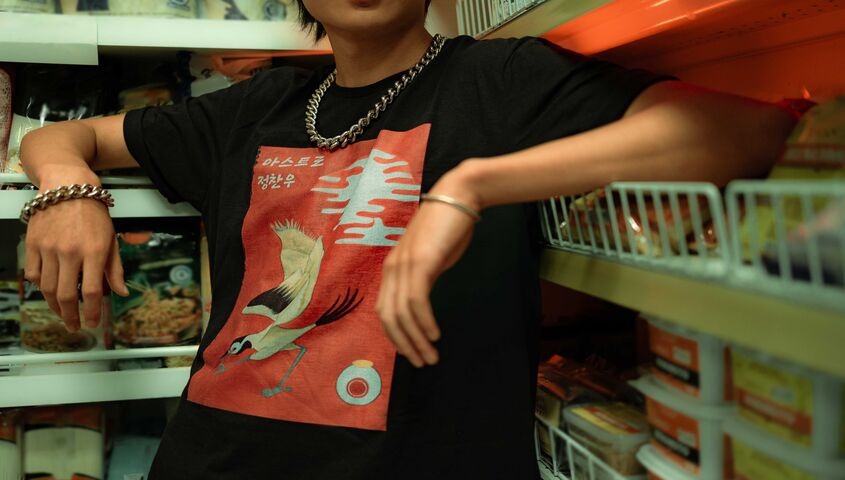 Model in a heavyweight boxy graphic tee inside a corner store, the silhouette driving print on demand trends 2026.