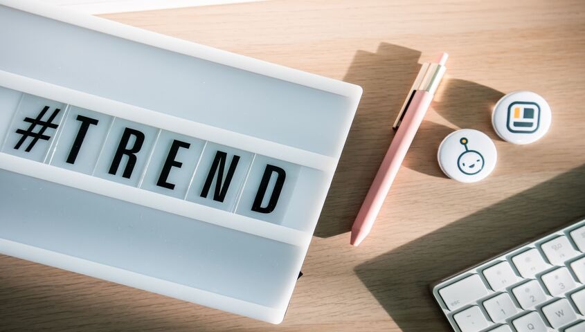 Lightbox spelling out TREND on a design desk, introducing the trending print on demand designs reordering in 2026.