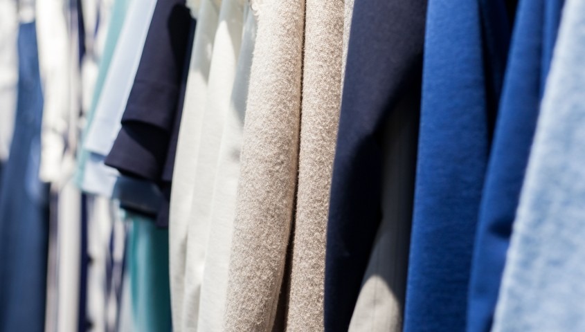 Clothing hanging in a boutique, showcasing fabric textures