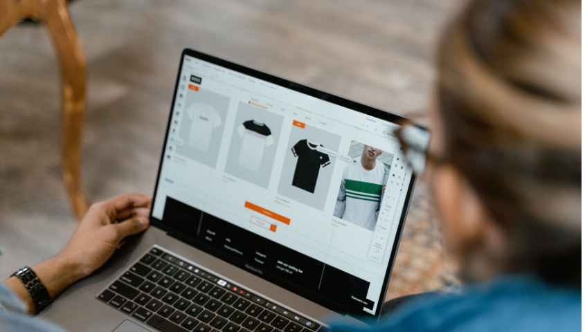 Two people collaborating on a laptop for t-shirt design and selection