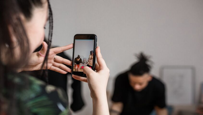 Person filming short-form content of two sellers on a phone, the weekly habit behind how to make money on tiktok shop.