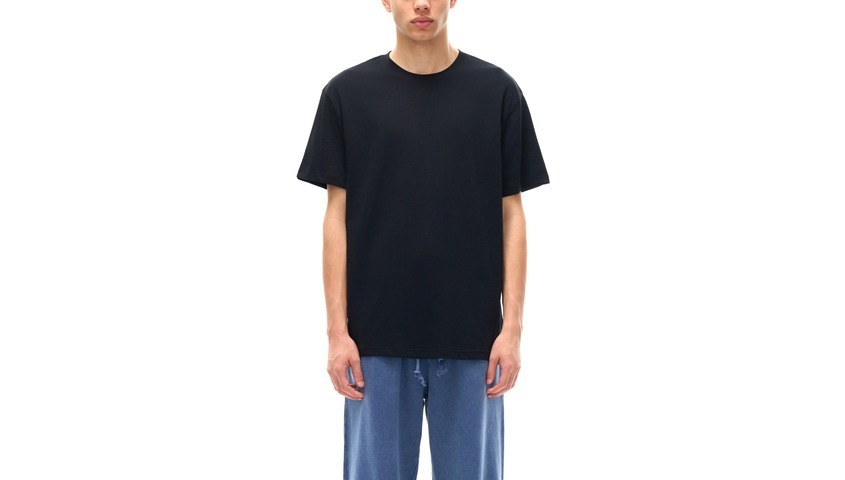  Model wearing a classic black cotton tee, the baseline answer to how much does a shirt weigh.