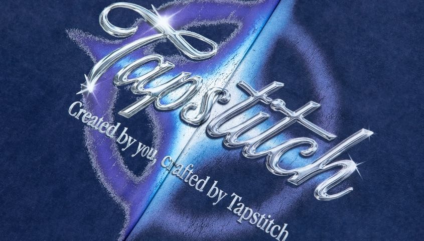 Close-up of a metallic-effect graphic printed across a seam on a navy garment