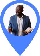 Man in a blue suit holding an open book and gesturing with his hand inside a blue map marker shape.