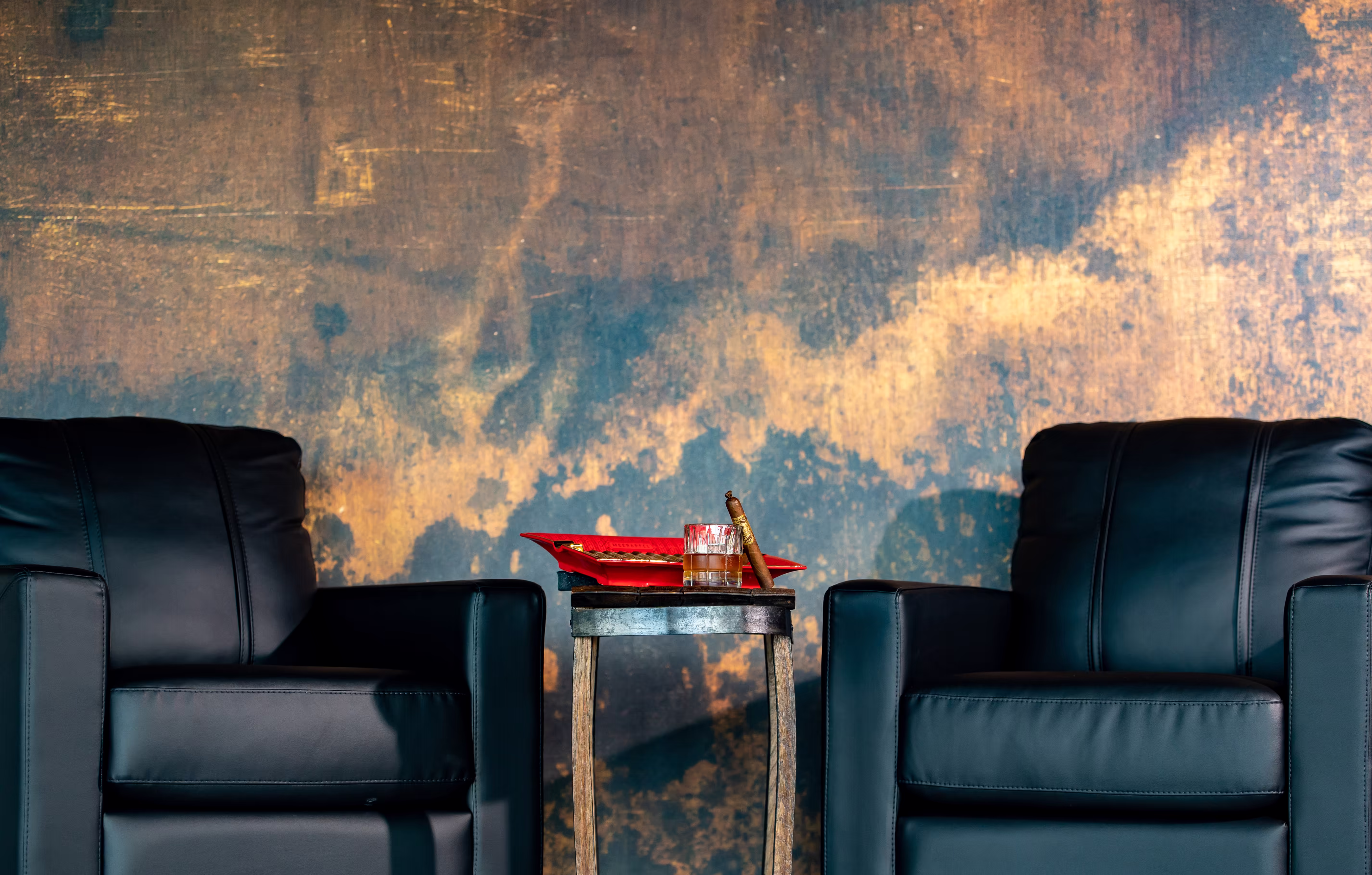 The Drawing Room Pittsburgh luxury seating flanking end table with cigars and spirits. Photo by Fisher Fotos