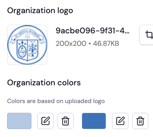 Circular organization logo with a shield divided into four sections, containing symbols like a cross, a Latin inscription, and botanical elements.