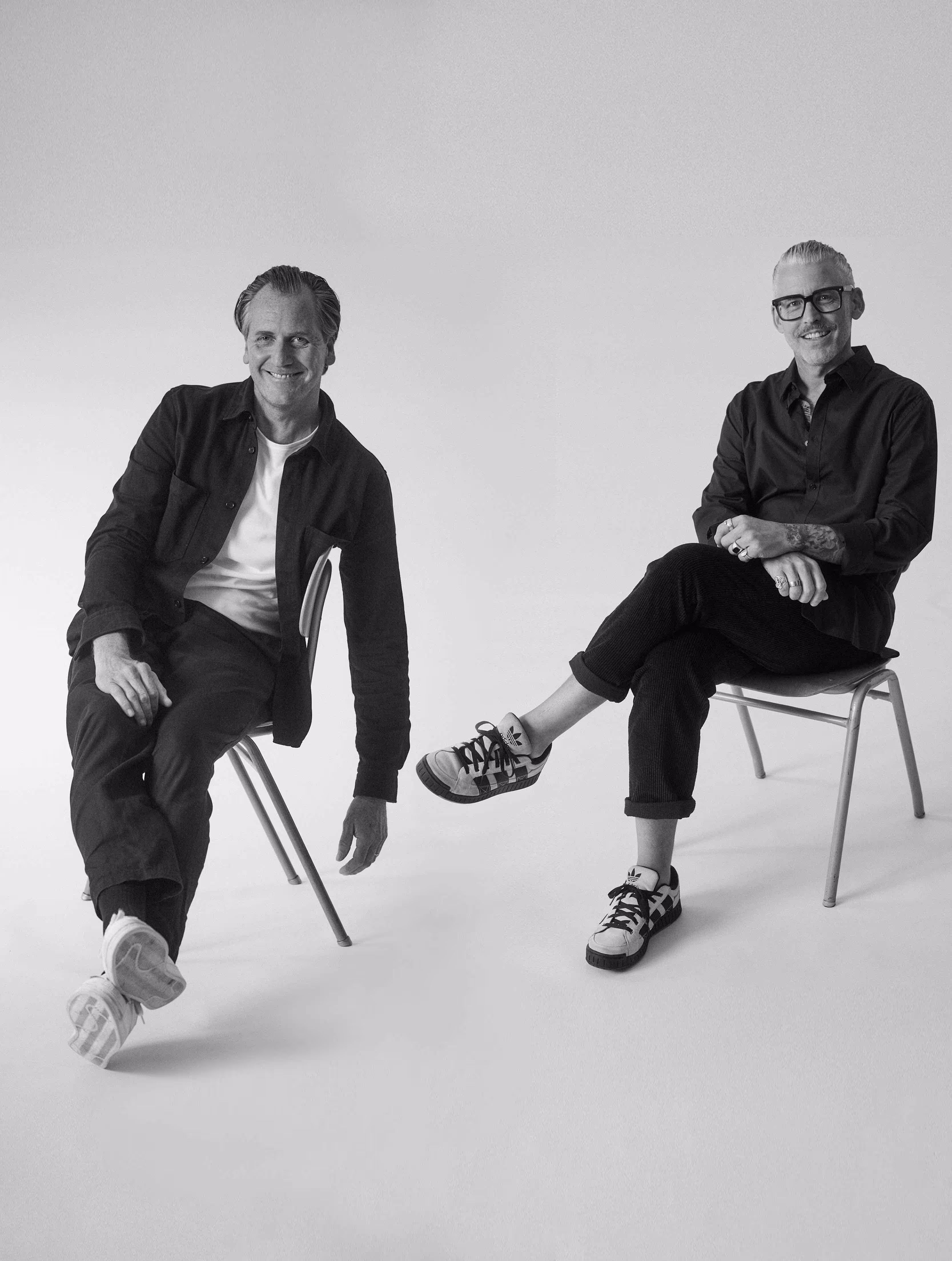 Das Kernteam der Tasteful Hospitality Agentur: Marc Übelherr und Markus Bauer, lächelnd und entspannt auf zwei Stühlen