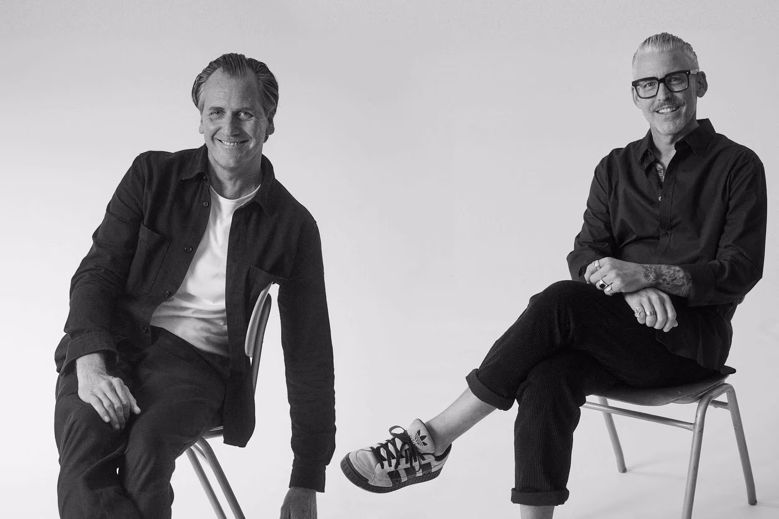 Das Kernteam der Tasteful Hospitality Agentur: Marc Übelherr und Markus Bauer, lächelnd und entspannt auf zwei Stühlen