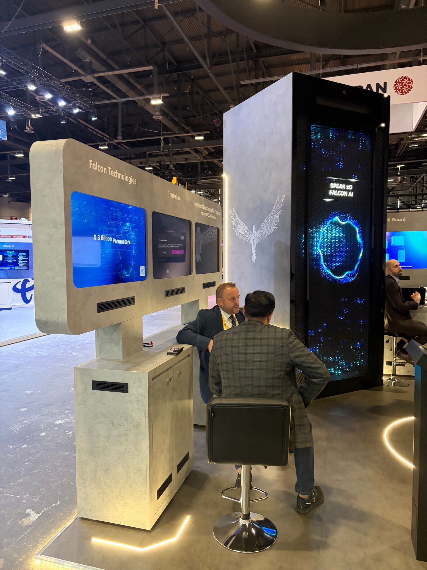 Falcon Technologies exhibition stand with an AI display and two people in conversation