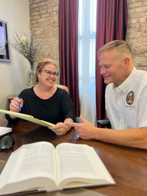 Kathleen Legendre smiling with client showing documents