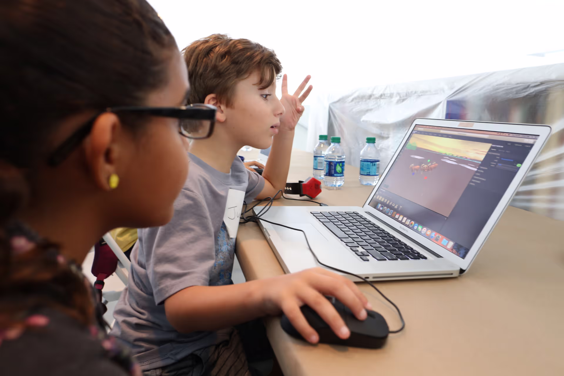 MUD Foundation XRCamp at the De La Cruz Collection in Miami, Florida, 2017, featuring two children working together at a table with a laptop displaying 3D design software and a colorful 3D model.