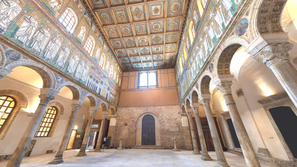 MUD Foundation Sant Apollinare Nuovo in Verse, featuring the interior of a historic church with tall arched columns, Byzantine mosaic artwork depicting figures along the upper walls, and a decorated wooden ceiling with square panels.