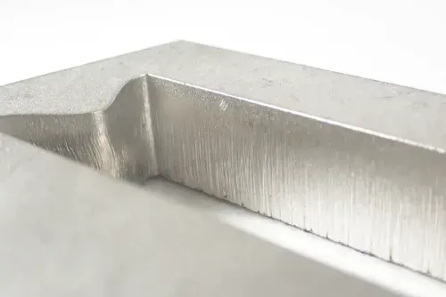 A close up of a machined piece of stainless steel
