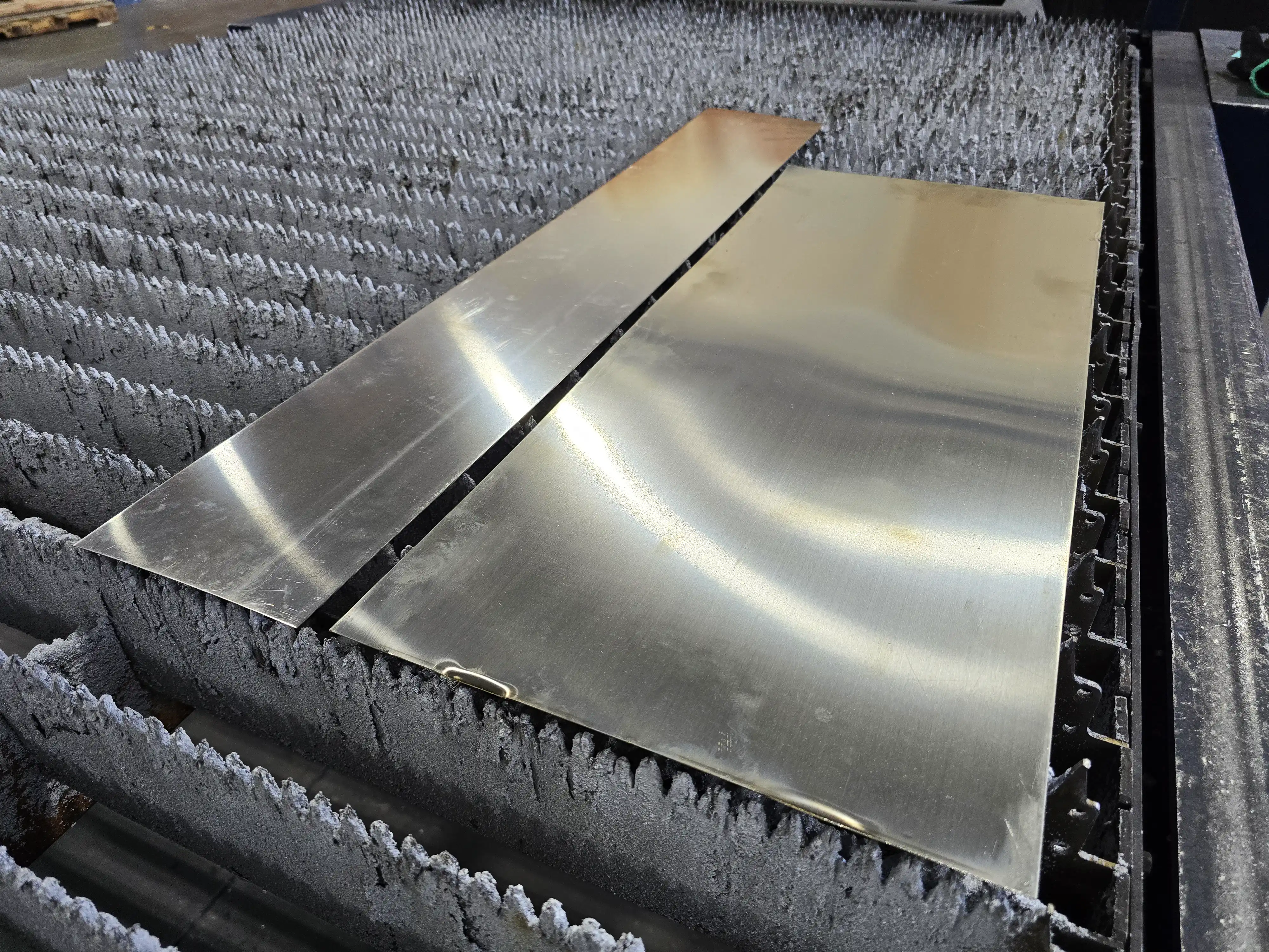Two nickel silver sheets on a laser cutting table