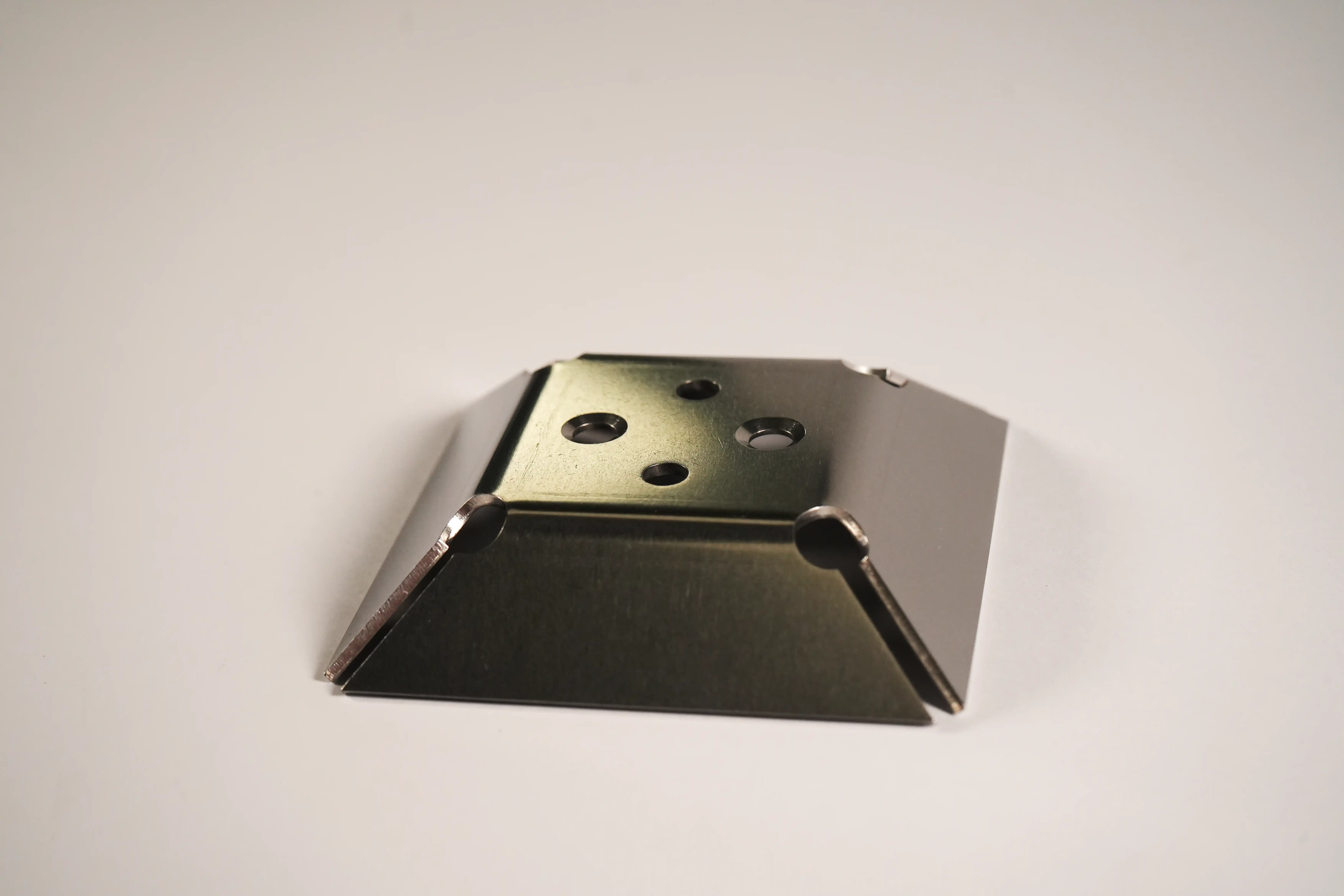 Tumbled bent metal part with countersunk holes