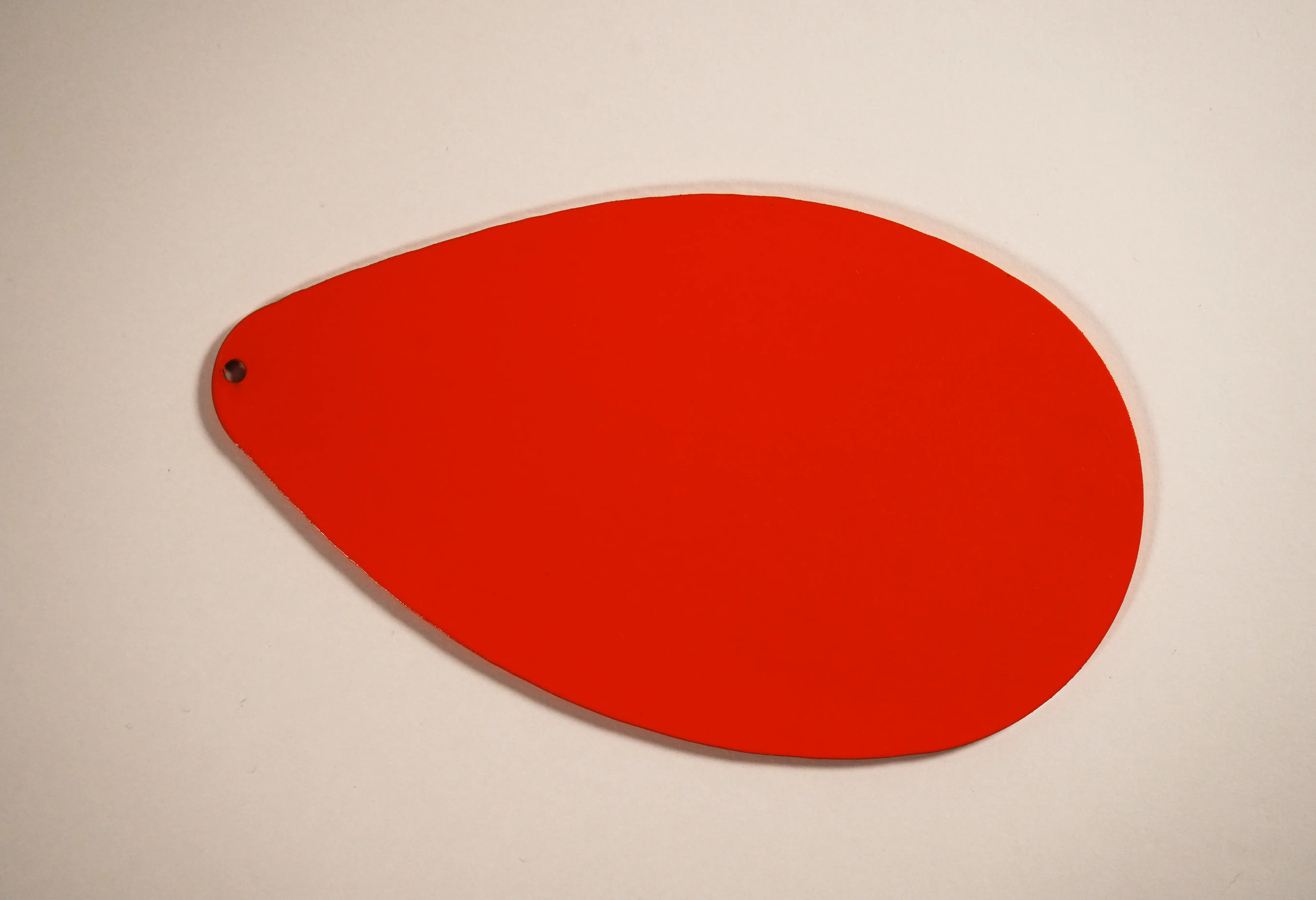 Red powder-coated teardrop-shaped part