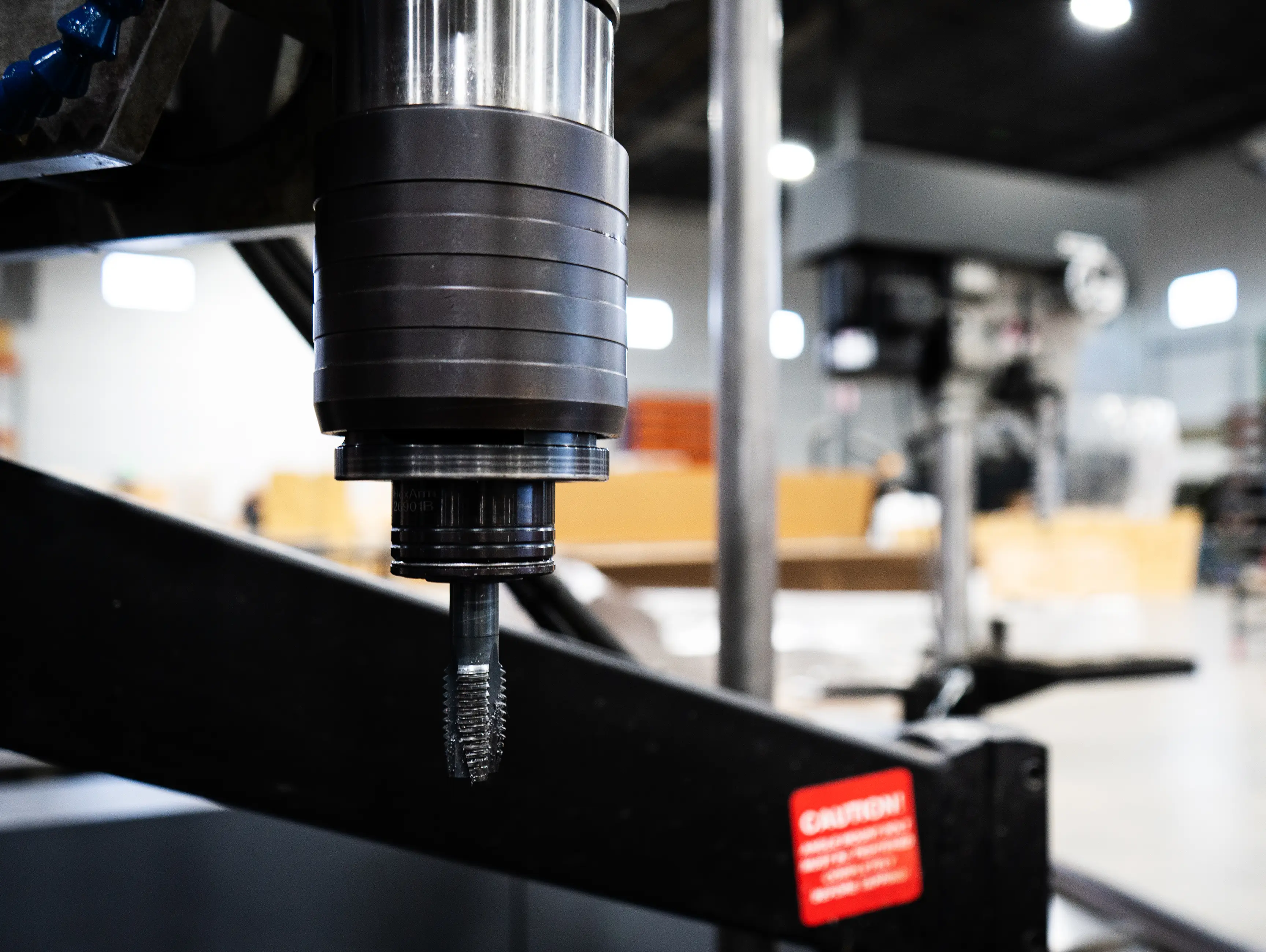 Tapping arm cutting threads with a tap