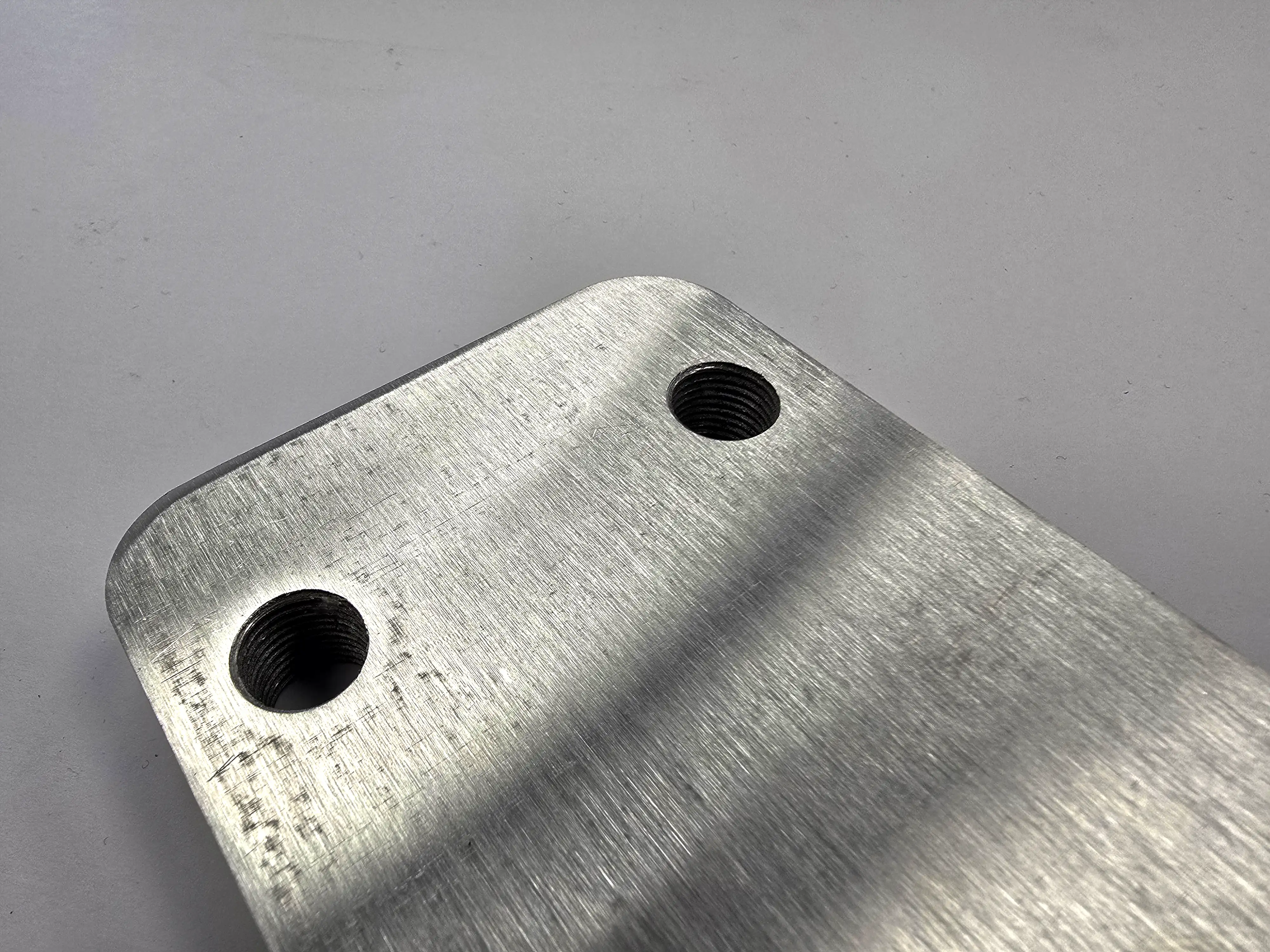 Thick metal plate with large tapped holes