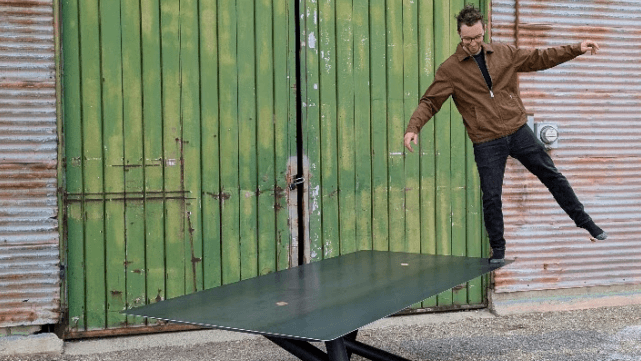 Sam Tresco of White Gorge Designs standing on one of his metal tables