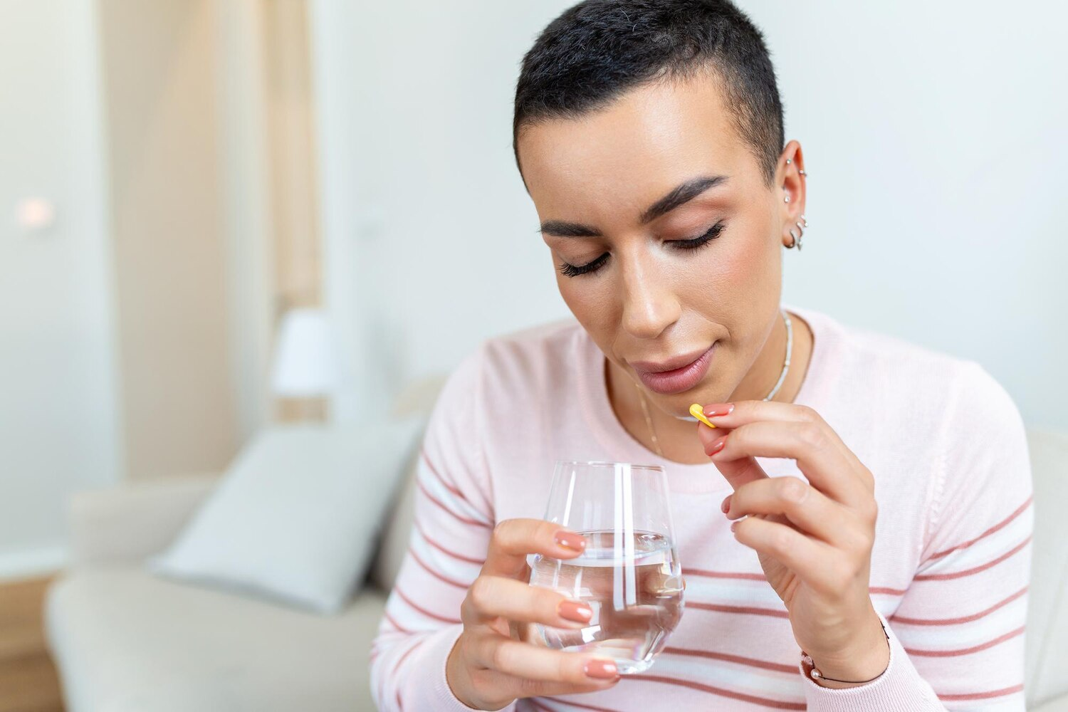 Person taking prescribed medication with water as part of a medication-assisted detox program under medical supervision