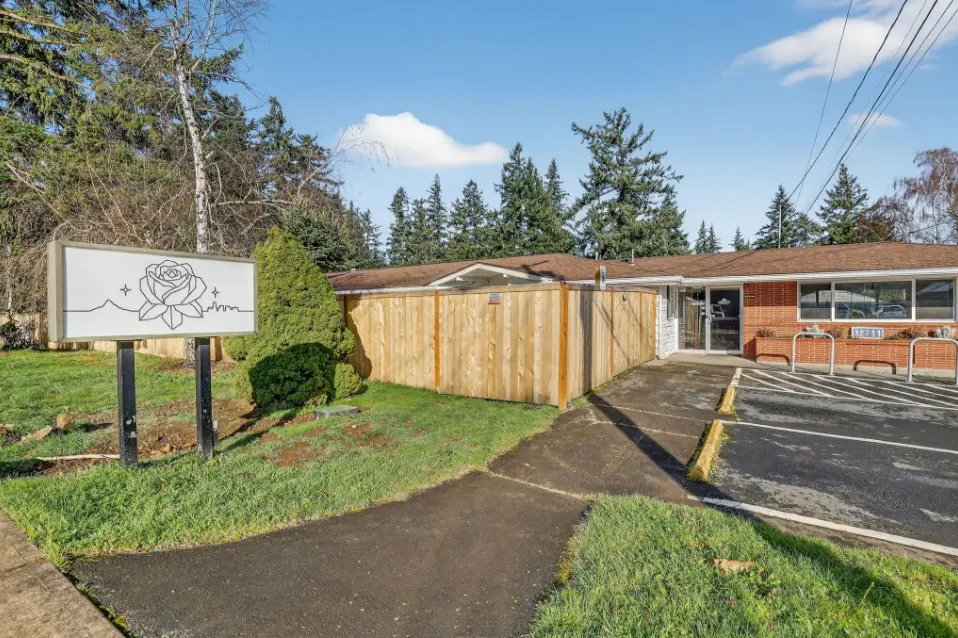 A calm residential building surrounded by mature trees in a Portland neighborhood