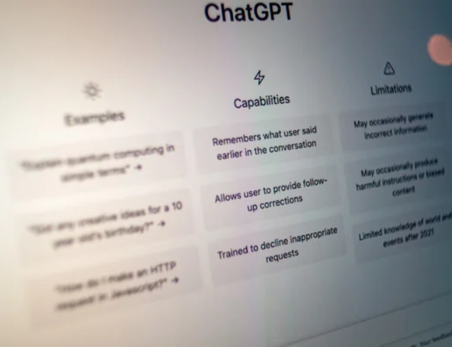 Computer monitor displaying the ChatGPT interface with sections for Examples, Capabilities, and Limitations.