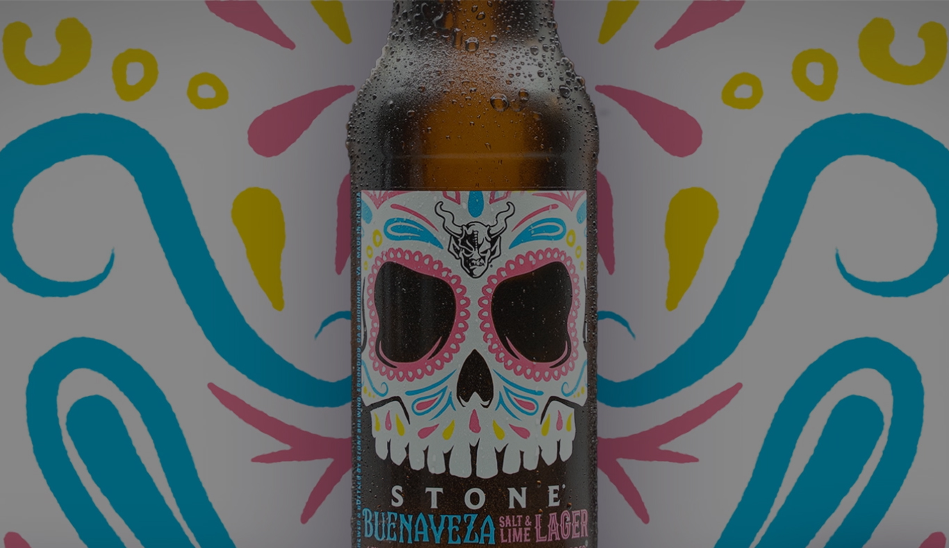Stone Buenaveza Salt & Lime Lager bottle featuring a sugar skull label against a colorful illustrated background.