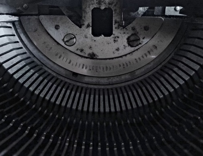 Extreme close-up of the inner mechanism and keys of an old black manual typewriter.