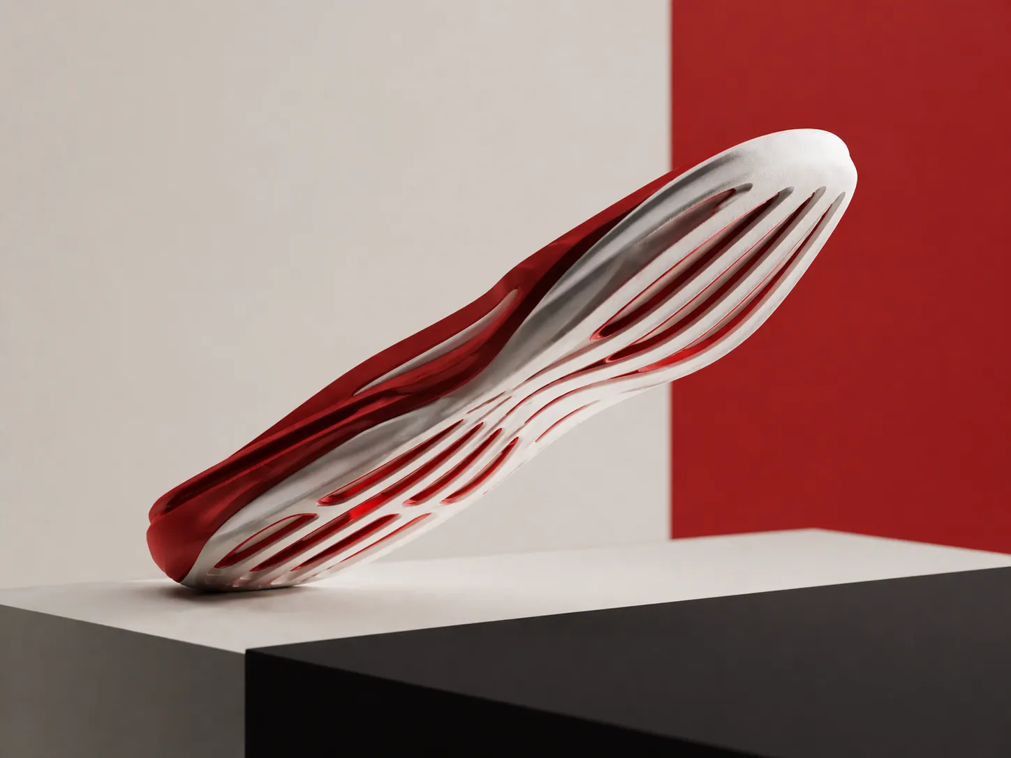 A sculptural shoe sole with aerodynamic grooves angled upward, suggesting motion, set against a clean red and neutral minimalist background.