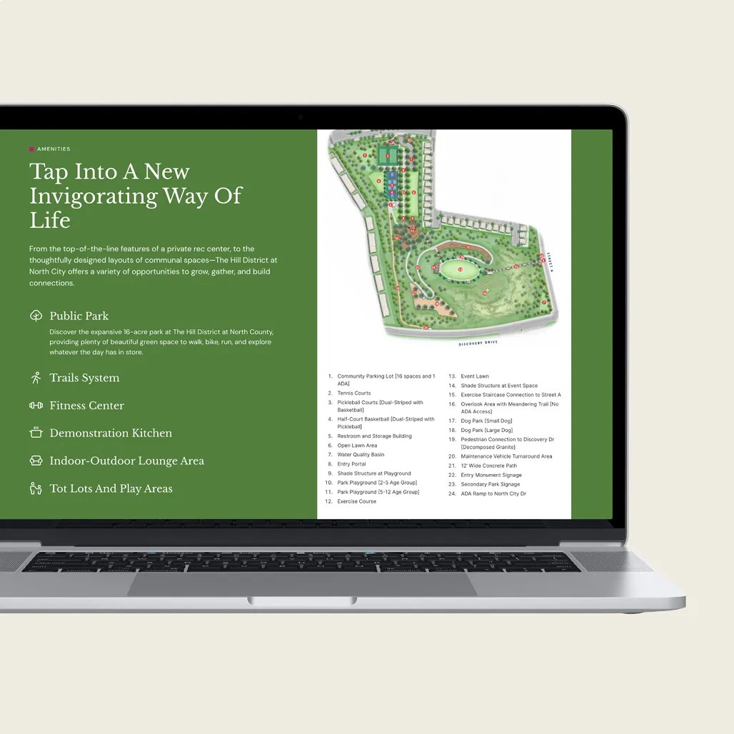 A laptop displaying The Hill District amenities page with a site map of the 16-acre public park and a list of community features.
