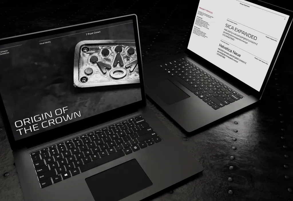 Two laptop mockups on dark steel showing the Origin of the Crown spread and Sica Expanded / Helvetica Neue typography page.