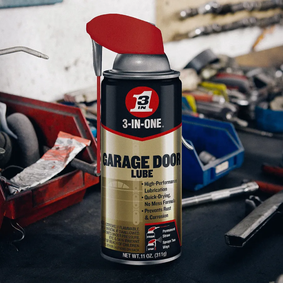 Can of 3-IN-ONE Garage Door Lube with red Smart Straw on a workbench, surrounded by tools and a parts bin.