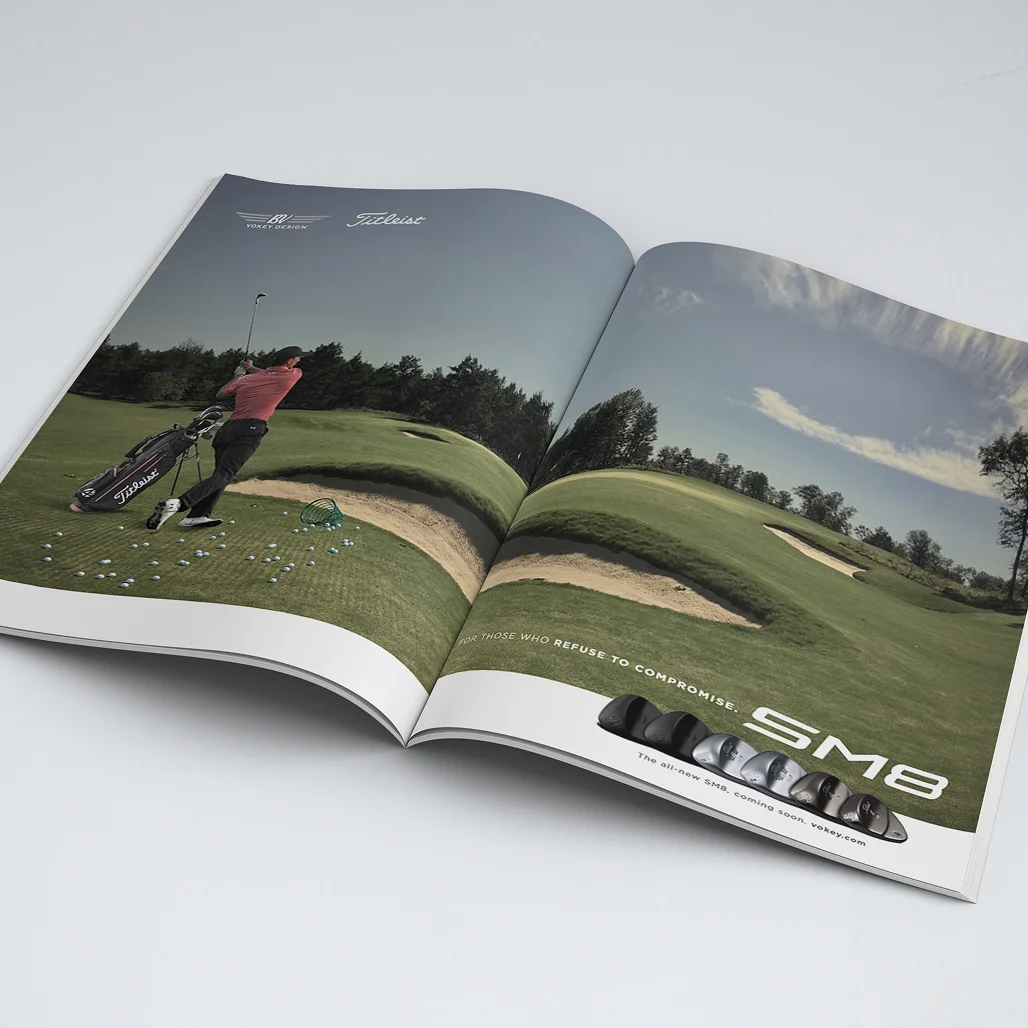 Open magazine spread with Vokey/Titleist SM8 ad showing a golfer's follow-through beside a bunker and lineup of wedge finishes.