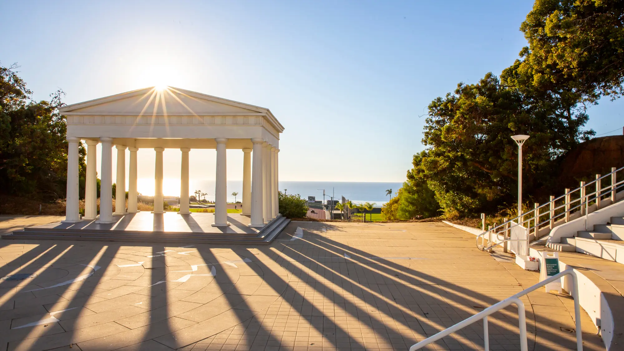 Sun shining through the Greek amphitheater colonnade on Point Loma Nazarene University's campus overlooking the ocean