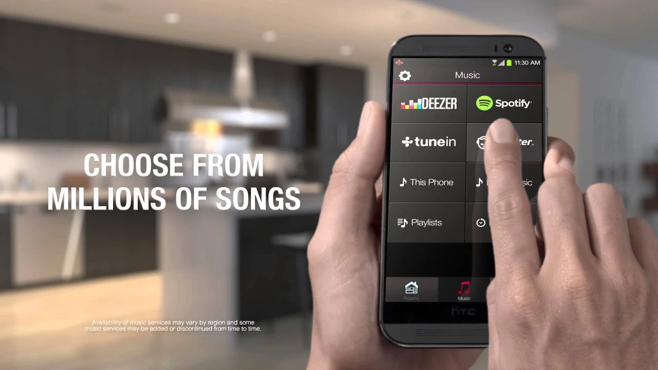 Hand tapping the HEOS app music menu on a phone with Spotify, Deezer, and TuneIn options and "Choose From Millions of Songs" text