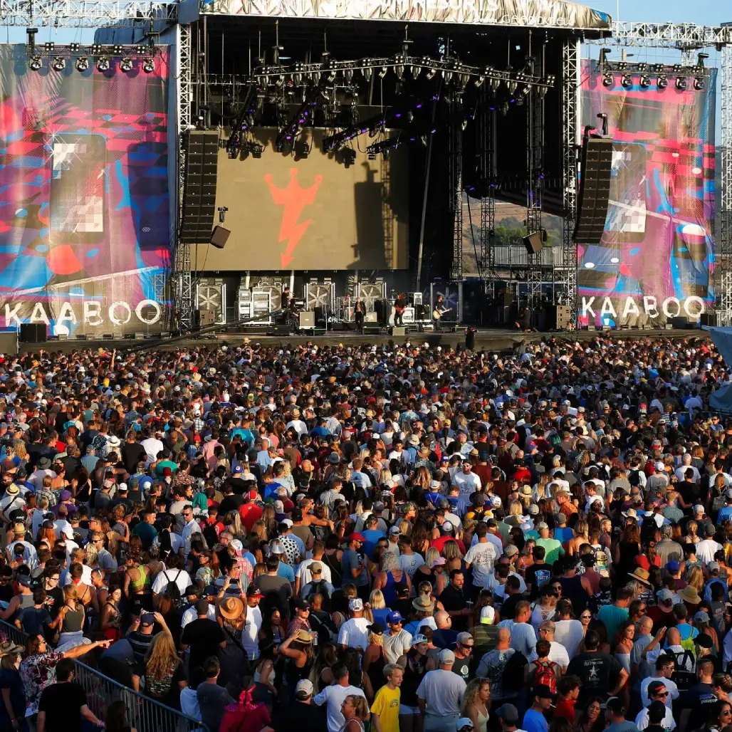 Large festival crowd watching a live band on the KAABOO main stage in front of big video screens