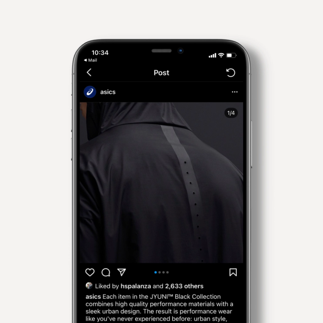 Phone screen showing ASICS Instagram post of the back of a black JYUNI Black Collection hooded jacket