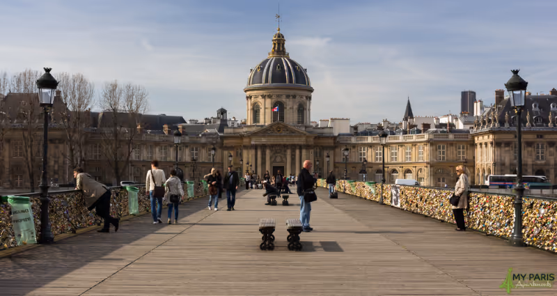 People walking along ‘Pont des Arts’ also knows as the love Lock Bridge