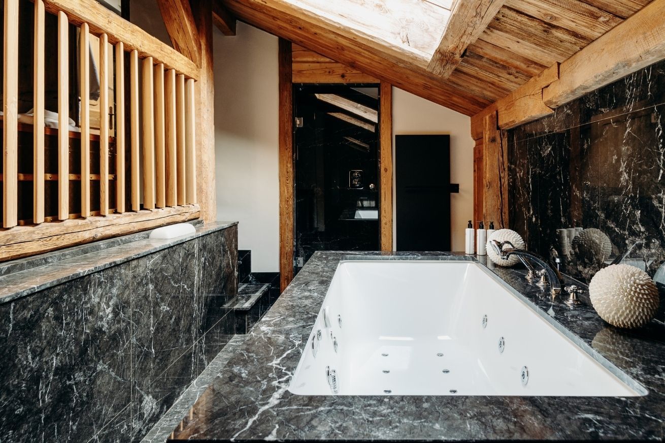 Salle de bain luxueuse avec baignoire et douche dans un hôtel 5 étoiles à Megève, pour un séjour de bien-être en Haute Savoie