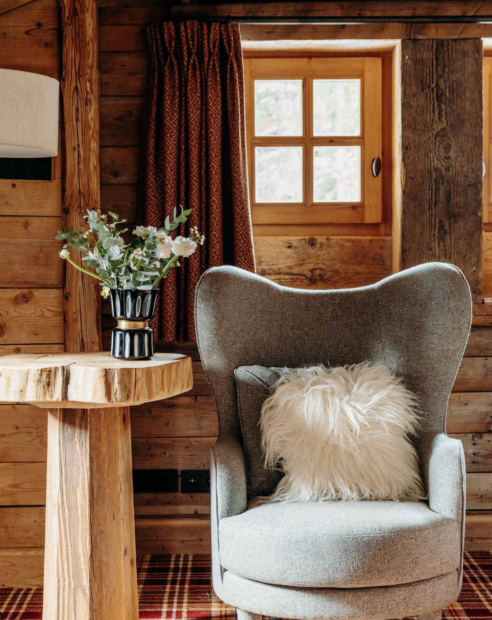 Coin détente au décor chaleureux et boisé dans une chambre des Chalets du Mont d’Arbois — Megève.