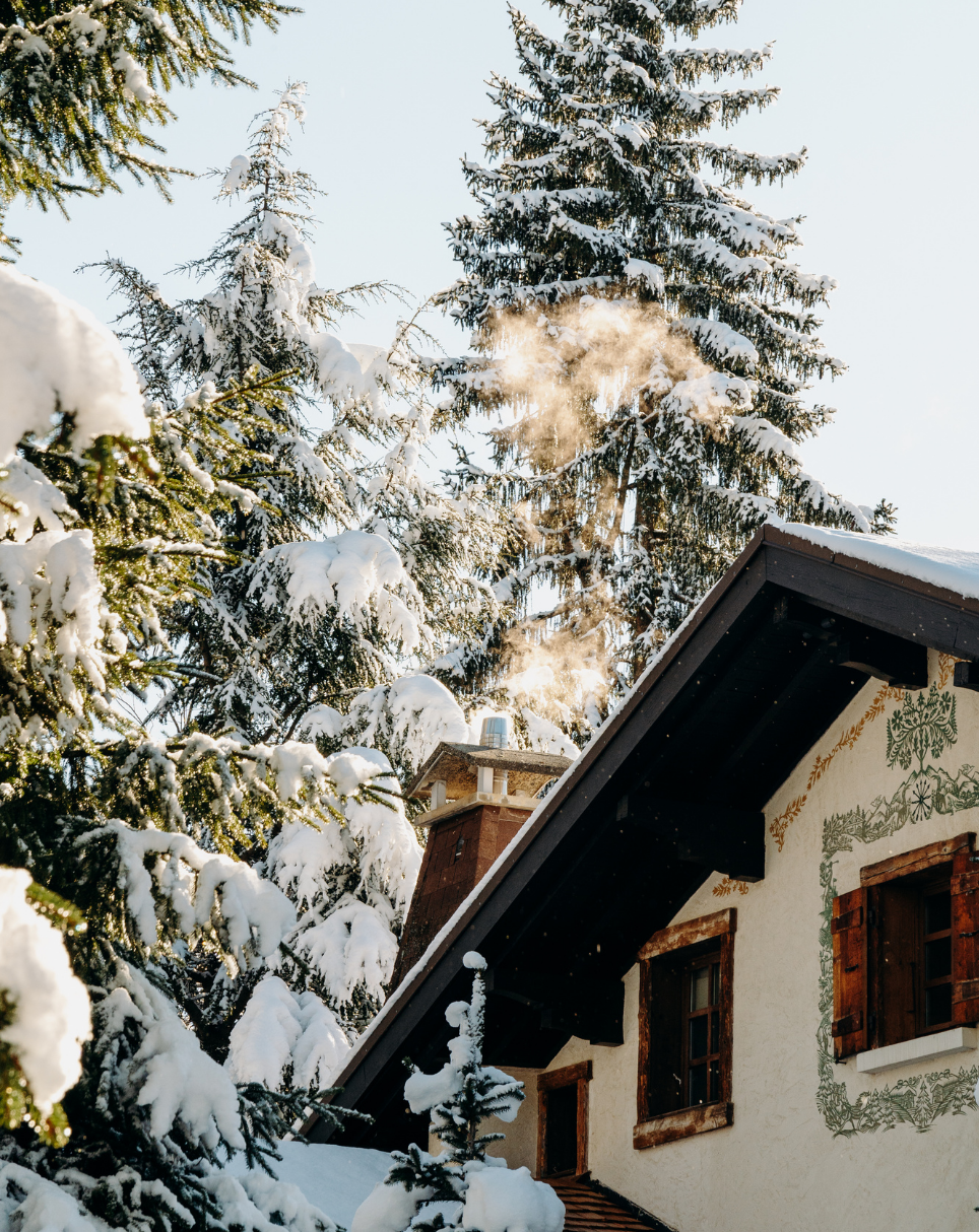 Chalet traditionnel entouré de sapins enneigés aux Chalets du Mont d’Arbois — Megève.