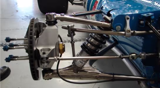 cận cảnh hệ thống treo và khung gầm của một chiếc xe đua, thể hiện công nghệ chế tạo xe hiệu suất cao.