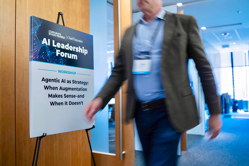 Sign for AI Leadership Forum workshop titled 'Agentic AI as Strategy: When Augmentation Makes Sense–and When It Doesn't' with a man walking past.