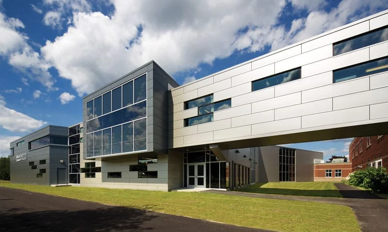 Modern paneled building with an elevated glass walkway at Manchester Community College, New Hampshire.