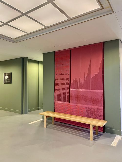 Foto van een groene muur met een rood wandkleed in het kantoorgebouw