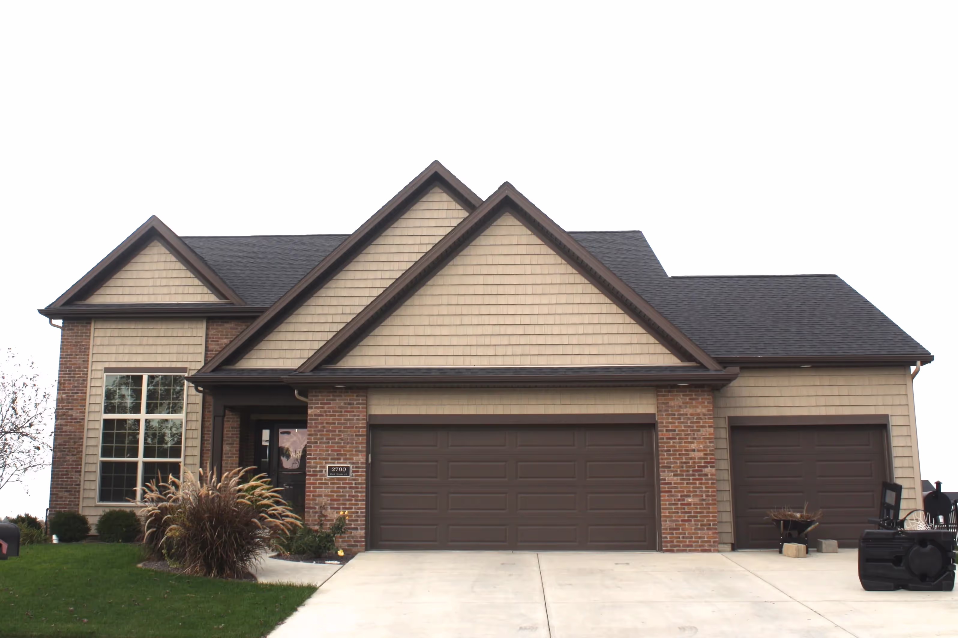 brown and brick home repainted by stampers painting co