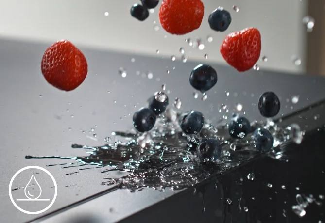 Nobilia-Keramikarbeitsplatte mit Beeren und Wassertropfen auf der dunklen Oberfläche.
