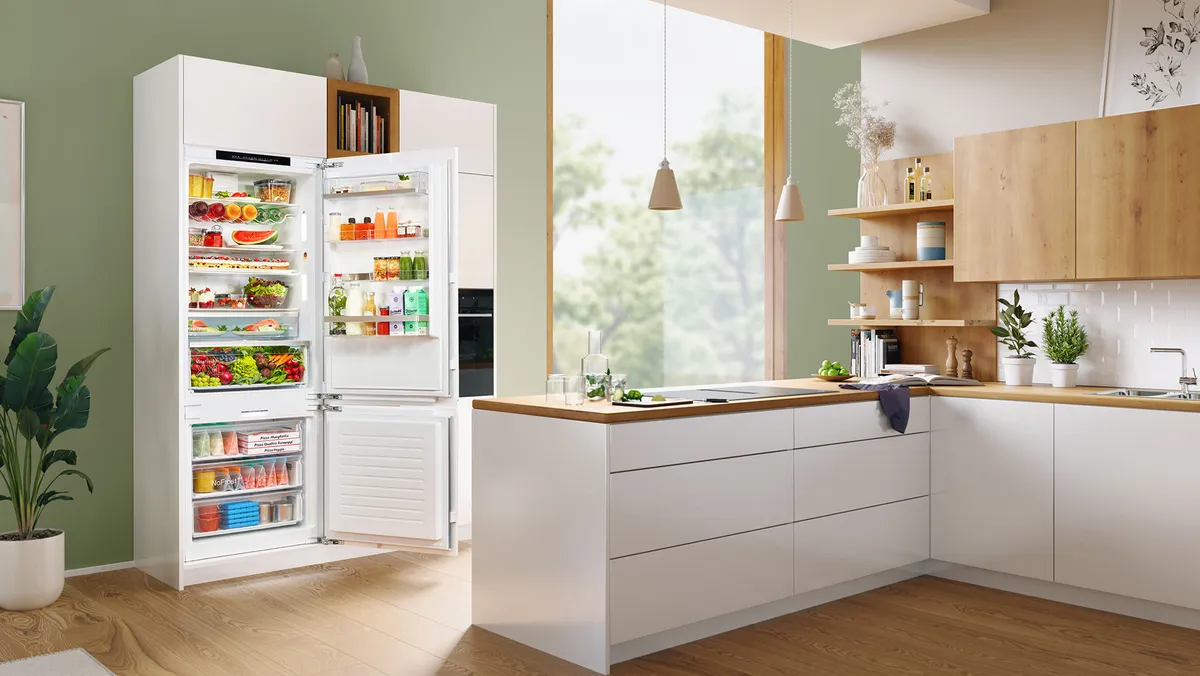 Geöffneter Bosch-XXL-Einbaukühlschrank mit Lebensmitteln, integriert in eine helle Küchenzeile.